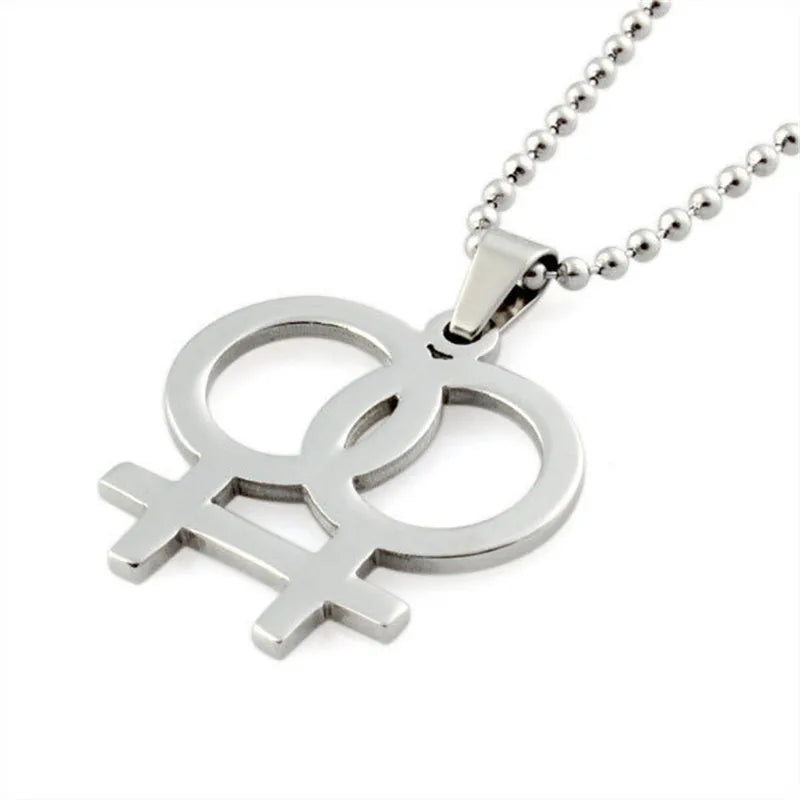 Silver necklace featuring a double gender symbol pendant on a dark surface. A key piece of lesbian fashion to define your lesbian style. Essential lesbian attire accessory for a confident lesbian outfit.