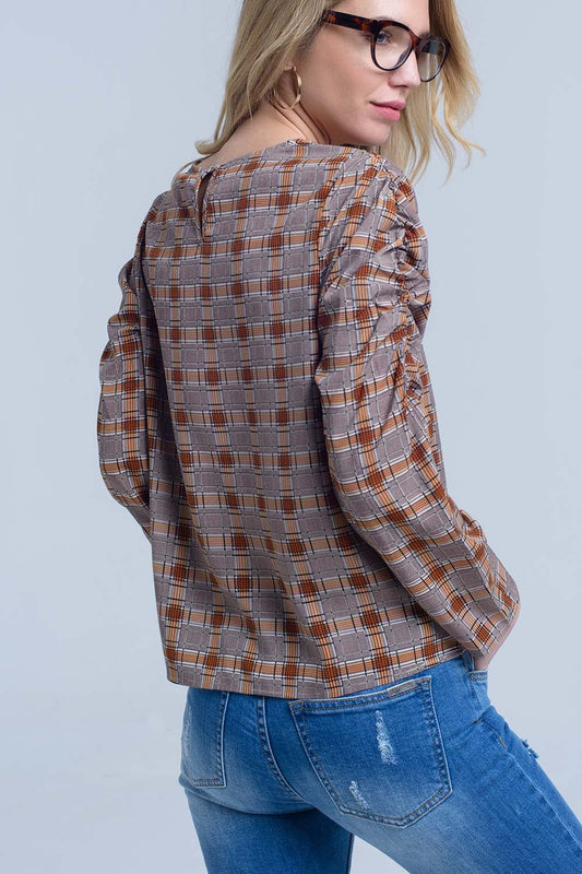 Woman wearing a classic plaid shirt and blue jeans against a light gray background. This iconic lesbian outfit is a perfect example of casual lesbian fashion and authentic lesbian style.