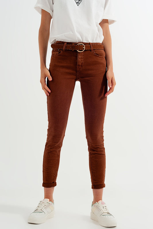 Person wearing classic brown jeans and a white shirt on a white background. This clean and confident lesbian outfit is a perfect example of casual lesbian fashion and authentic lesbian style.