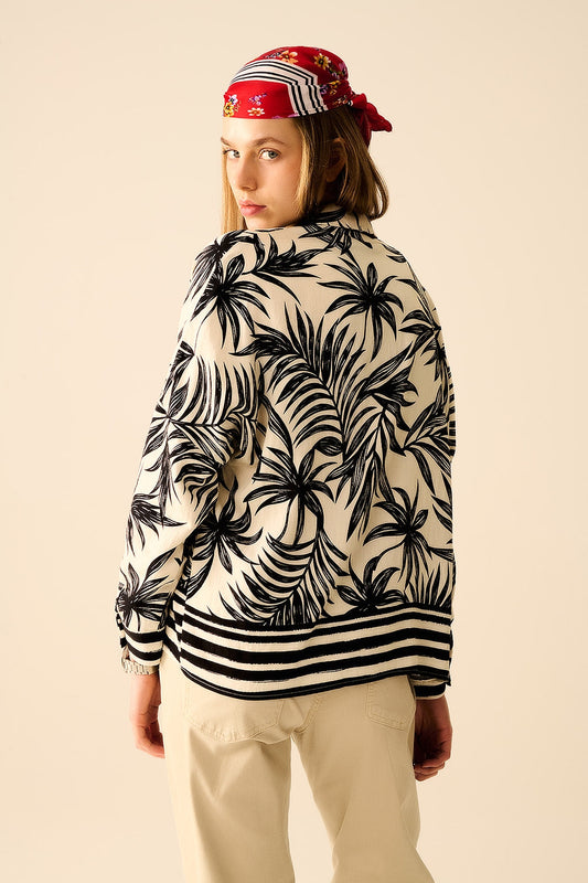 Person wearing a patterned shirt with palm leaves and a bright red headband against a beige background. This confident lesbian outfit is a perfect example of casual lesbian fashion and authentic lesbian style.