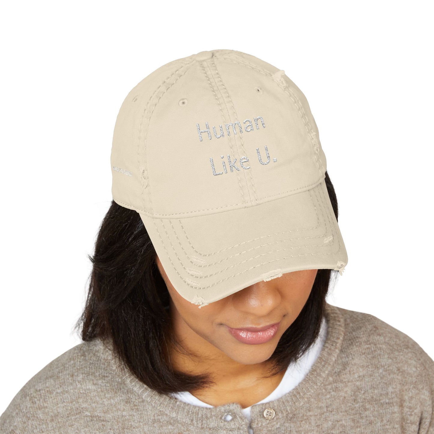 Person wearing a stylish beige cap with 'Human Like U.' text branding against a white background. This neutral headwear is an essential accessory for defining authentic lesbian style and relaxed lesbian fashion.