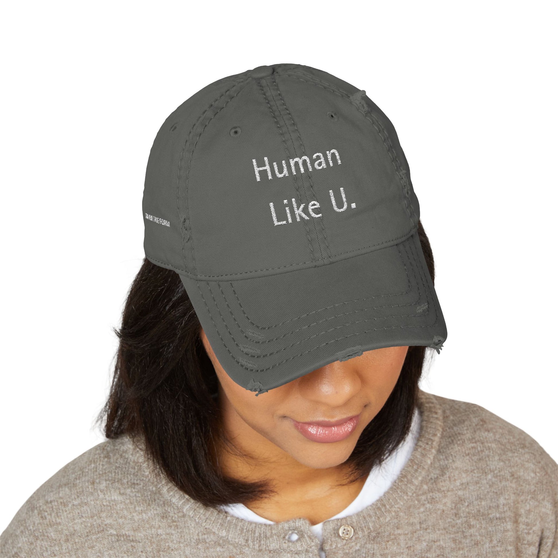 Person wearing a stylish gray cap with 'Human Like U.' text branding on a white background. This headwear is an essential accessory for defining authentic lesbian style and confident lesbian fashion.
