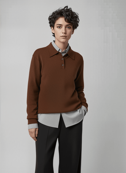 Person wearing a layered brown sweater over a light shirt with sharp dark pants against a plain background. This confident lesbian outfit is a perfect example of classic lesbian fashion and authentic lesbian style.