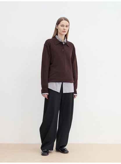 Person wearing a cozy brown sweater over a light shirt with sharp black pants against a white background. This classic lesbian outfit is a perfect example of confident lesbian fashion and authentic lesbian style.