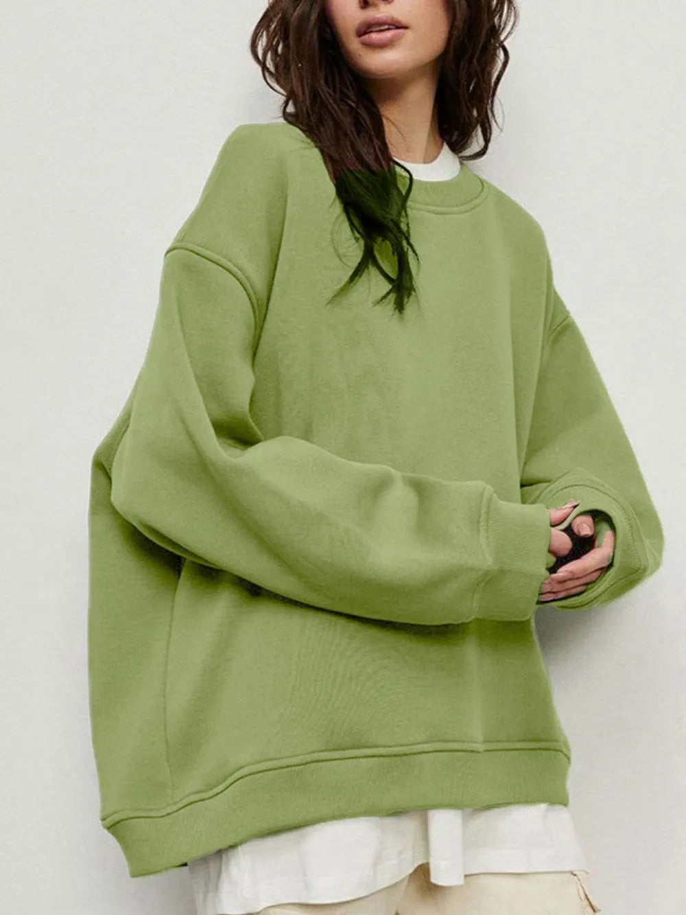 Person wearing a comfortable green oversized sweatshirt on a plain background. This classic lesbian outfit is a perfect example of casual lesbian clothing and relaxed lesbian style.
