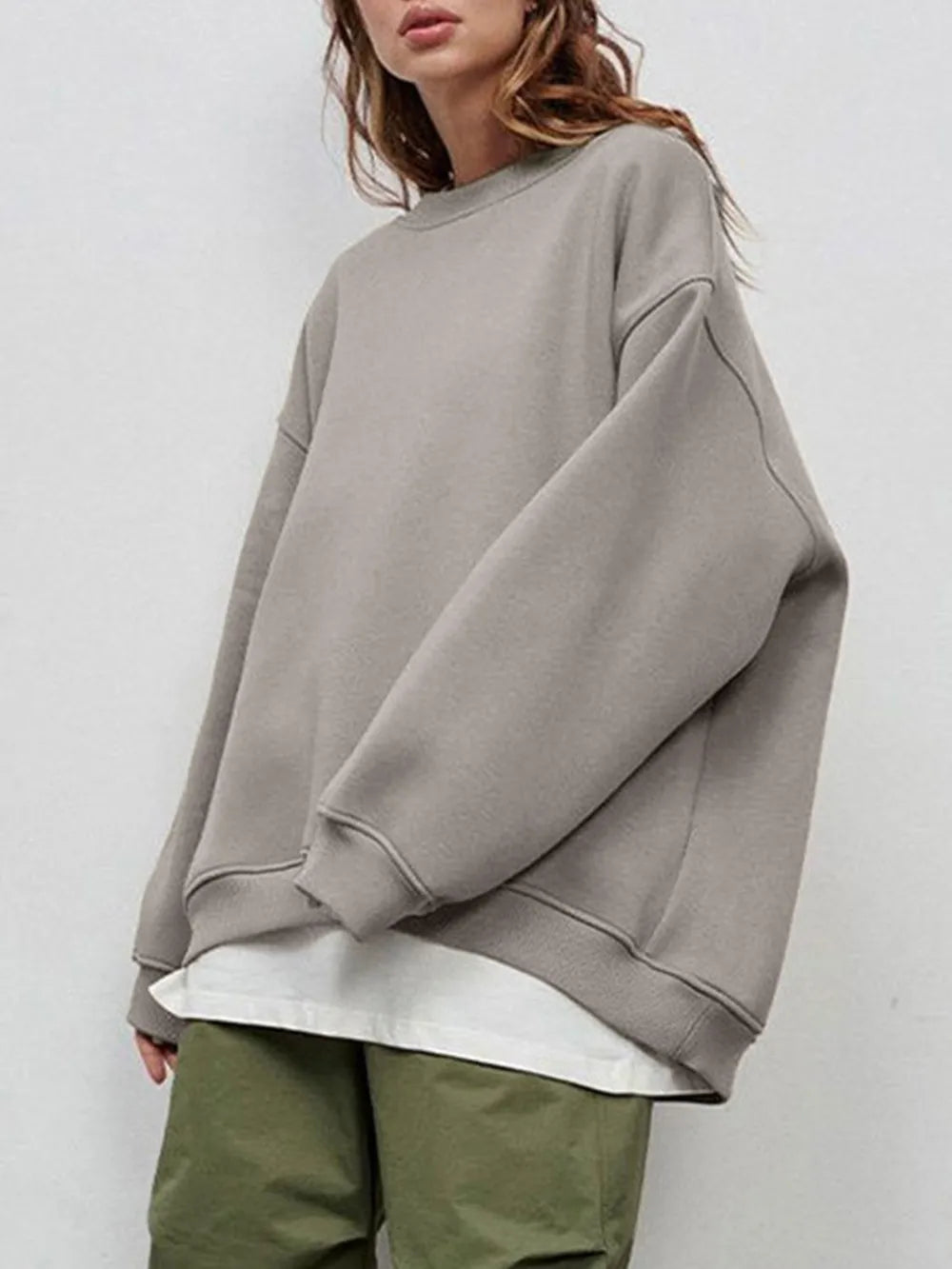 Person wearing a comfortable gray oversized sweatshirt on a plain background. This classic lesbian outfit is a perfect example of casual lesbian clothing and authentic lesbian style.