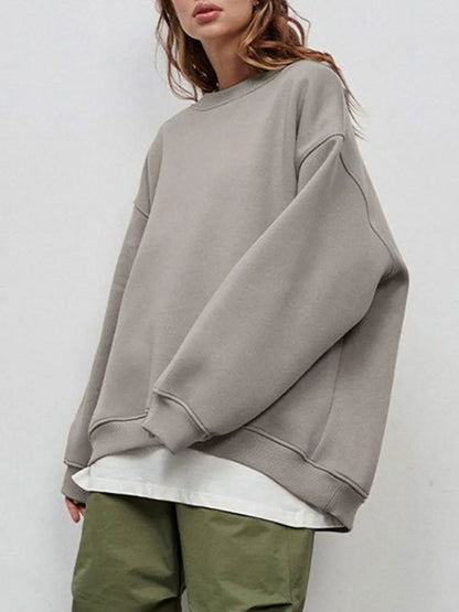Person wearing a comfortable gray oversized sweatshirt on a plain background. This classic lesbian outfit is a perfect example of casual lesbian clothing and authentic lesbian style.