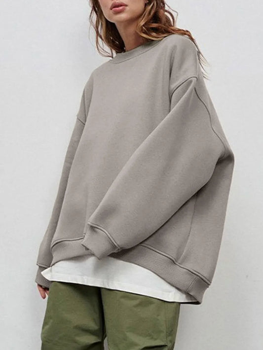 Person wearing a comfortable gray oversized sweatshirt on a plain background. This classic lesbian outfit is a perfect example of casual lesbian clothing and authentic lesbian style.
