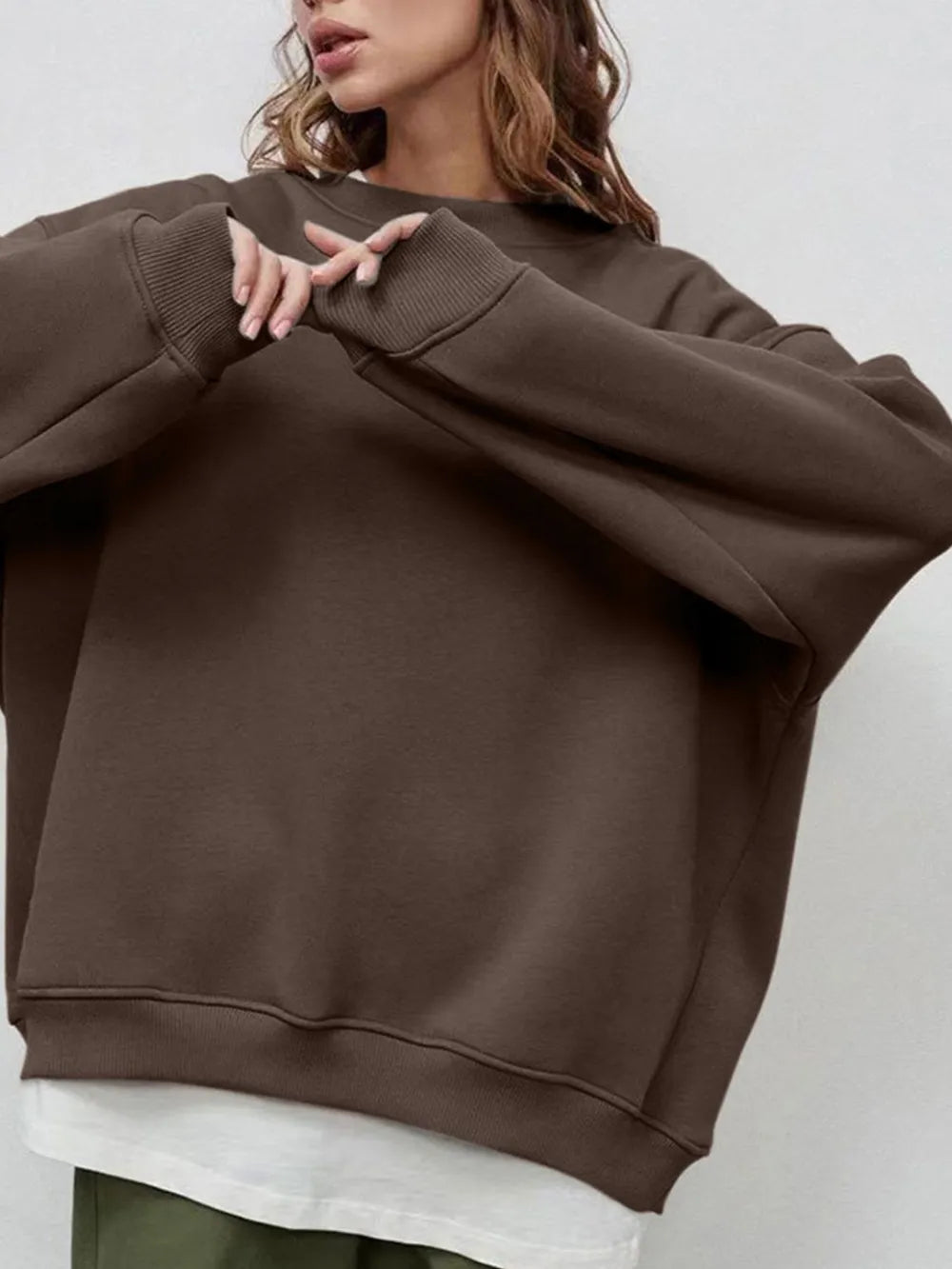 Person wearing a comfortable brown oversized sweatshirt on a plain background. This classic lesbian outfit is a perfect example of casual lesbian clothing and relaxed lesbian style
