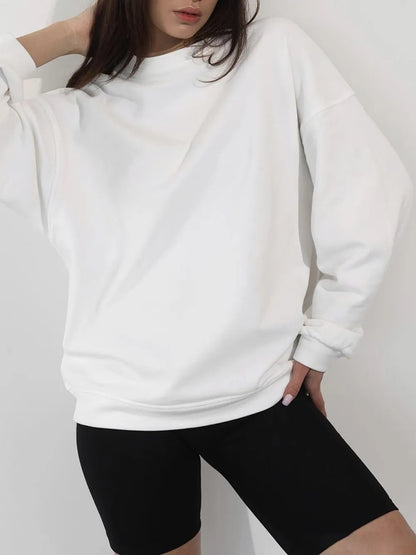 Person wearing a crisp white sweatshirt and sharp black shorts against a plain background. This comfortable lesbian outfit is a perfect example of casual lesbian fashion and authentic lesbian style.