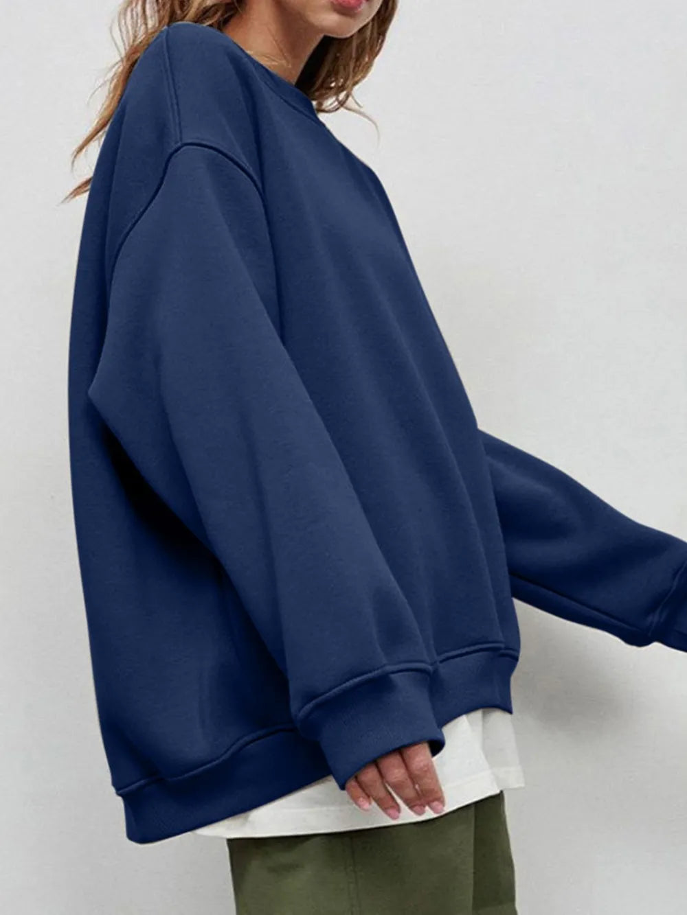Person wearing a comfortable blue sweatshirt with a plain background. This classic lesbian outfit is a perfect example of casual lesbian clothing and relaxed lesbian style.