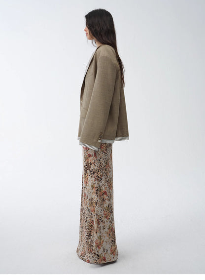 Woman wearing a soft green cardigan over vibrant floral pants on a white background. This comfortable lesbian outfit is a strong example of cozy lesbian fashion and playful lesbian style.