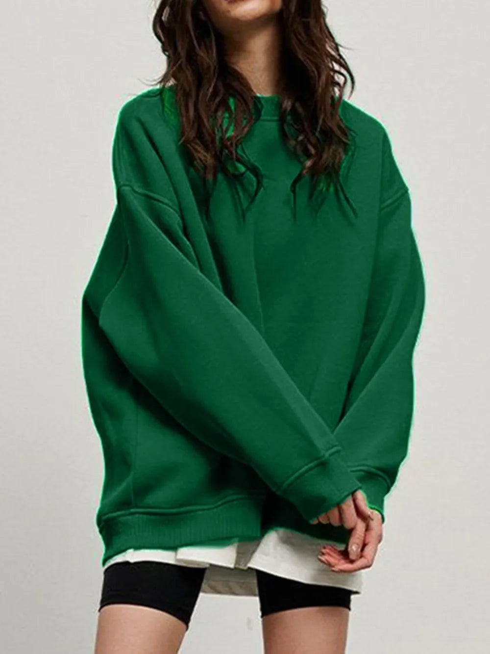 Person wearing a comfortable green sweatshirt on a plain background. This classic lesbian outfit is a perfect example of casual lesbian clothing and relaxed lesbian style.