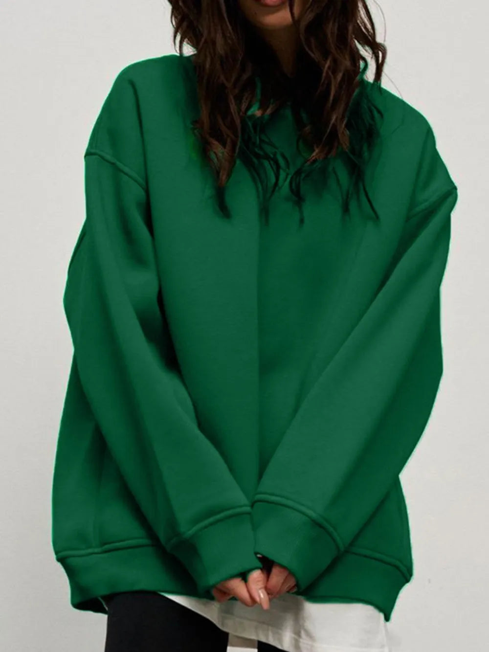 Person wearing a comfortable green sweatshirt on a plain background. This classic lesbian outfit is a perfect example of casual lesbian clothing and relaxed lesbian style.