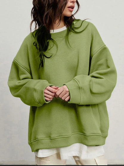 Person wearing a comfortable green oversized sweatshirt on a plain background. This classic lesbian outfit is a perfect example of casual lesbian clothing and relaxed lesbian style.