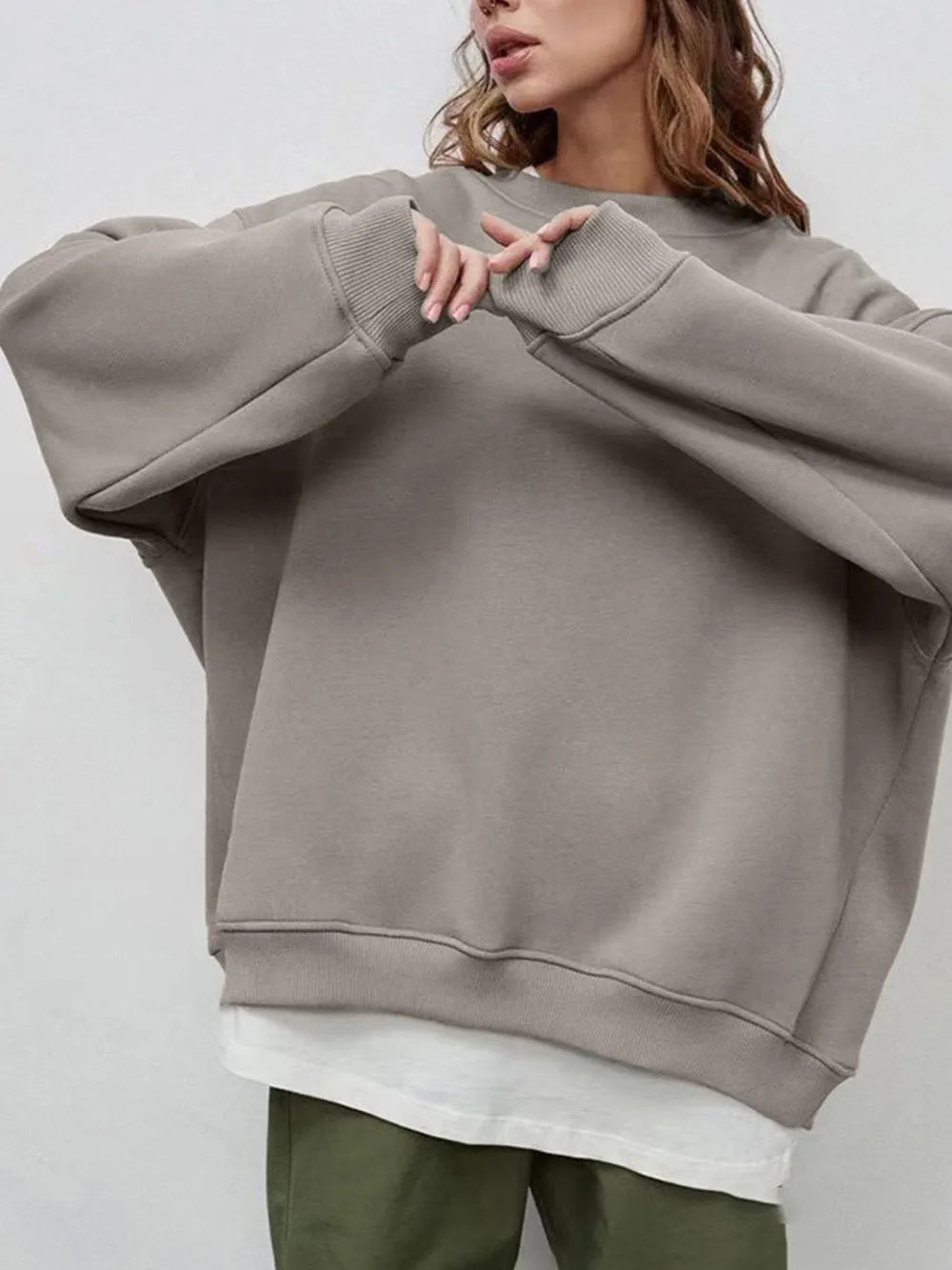 Person wearing a comfortable gray oversized sweatshirt on a plain background. This classic lesbian outfit is a perfect example of casual lesbian clothing and authentic lesbian style.