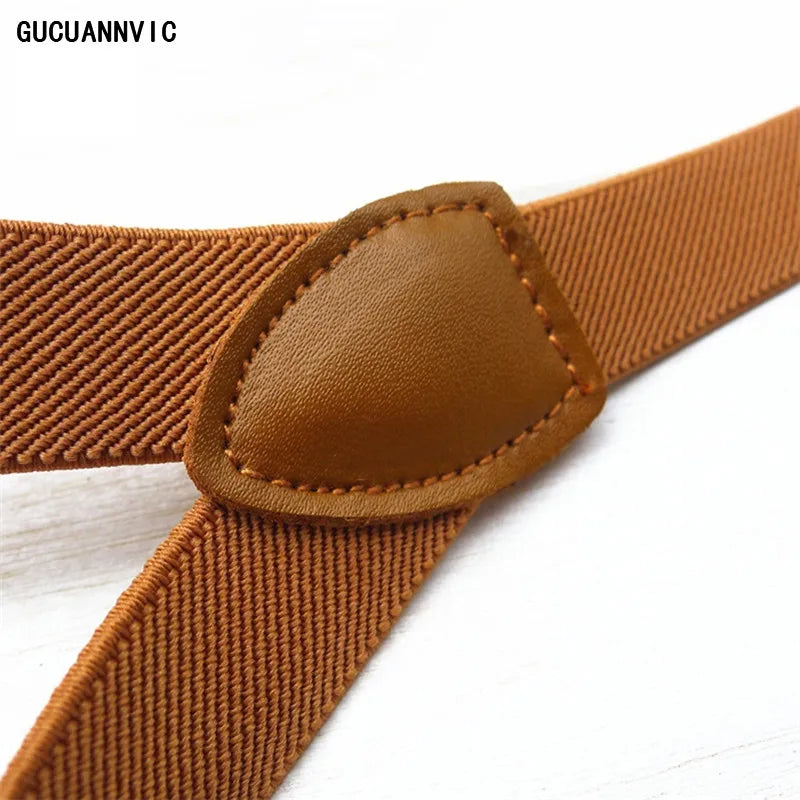 Close-up of classic brown suspenders with a leather strap and metal hardware on a white background. These sharp accessories are essential for building a confident lesbian outfit and authentic lesbian style.