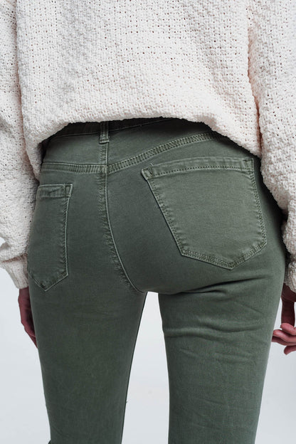 Person modeling green pants on a plain background. These comfortable lesbian clothing trousers are a staple of confident, everyday lesbian style and a sharp lesbian outfit.