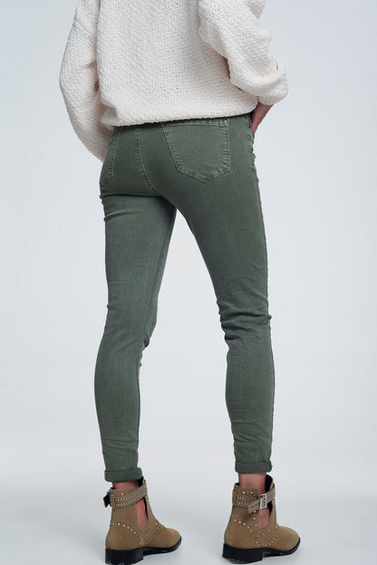 Person modeling green pants and a cozy white sweater on a plain background. This comfortable lesbian outfit is a strong example of essential lesbian clothing and confident lesbian style.