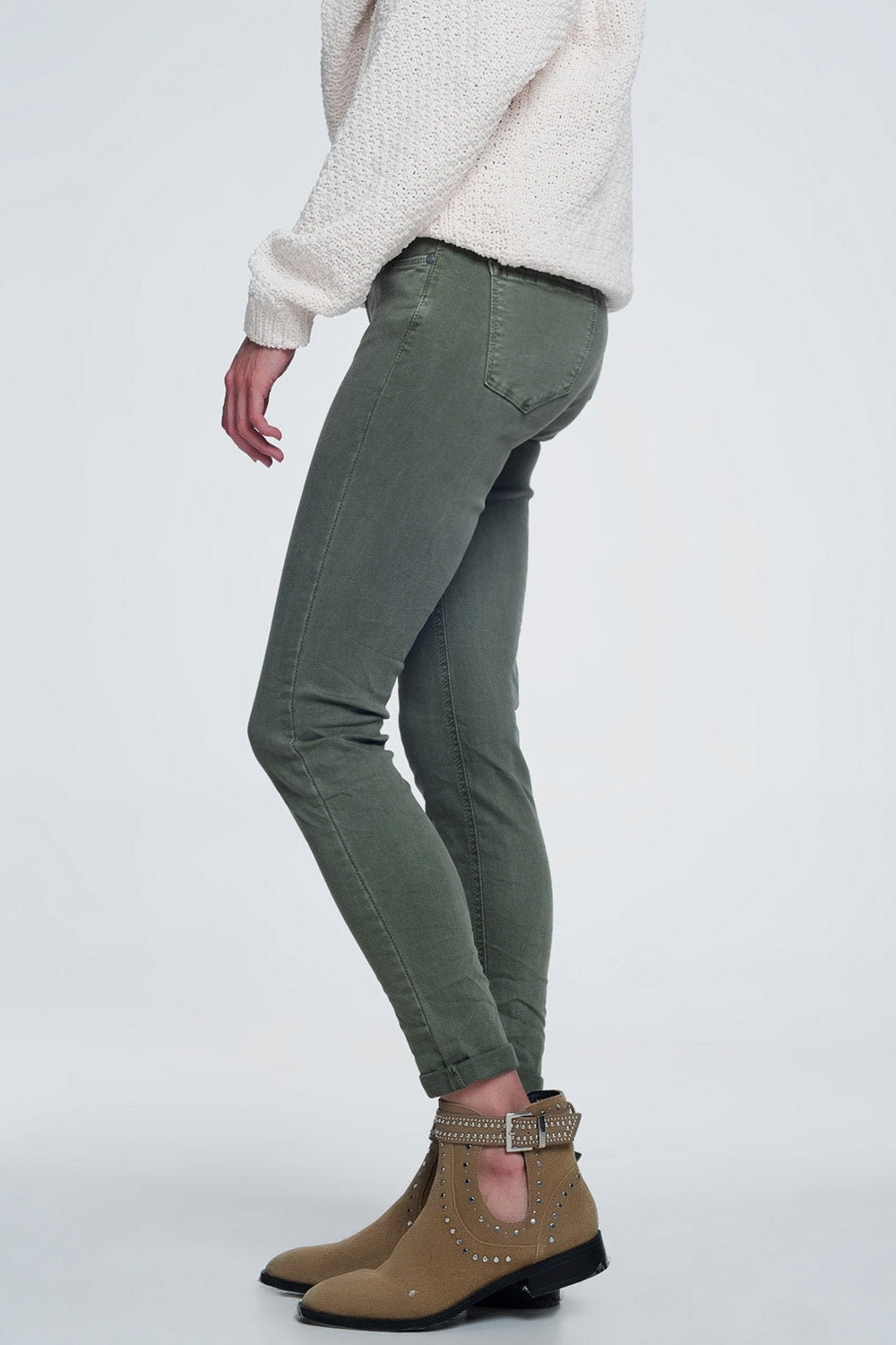 Person modeling green jeans and brown boots on a white background. This sharp, casual lesbian outfit is a perfect example of confident lesbian fashion and authentic lesbian style.