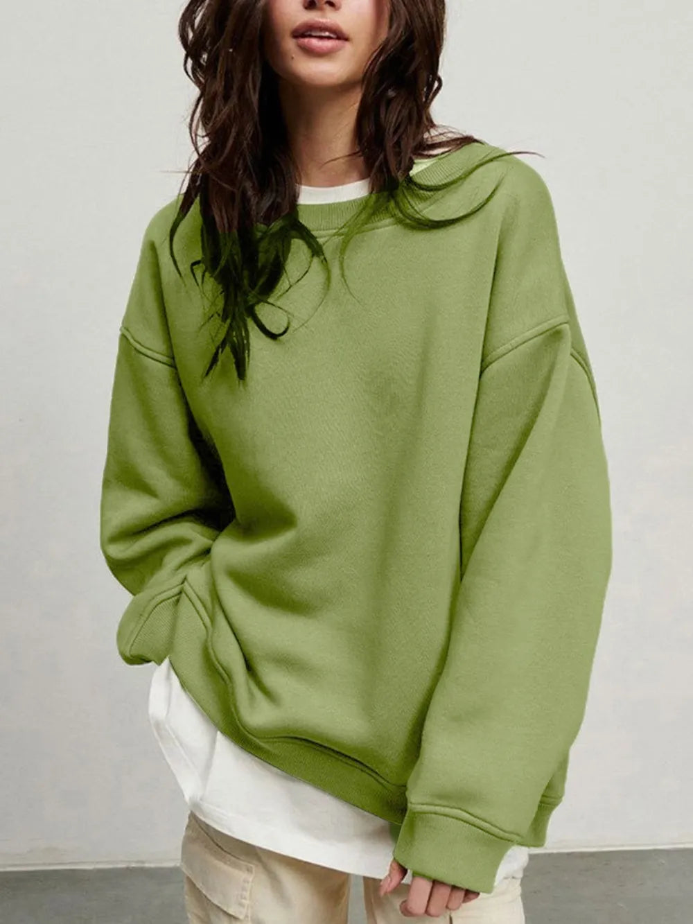 Person wearing a comfortable green oversized sweatshirt on a plain background. This classic lesbian outfit is a perfect example of casual lesbian clothing and relaxed lesbian style.