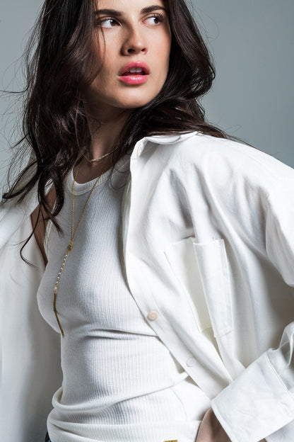 Woman modeling a clean, confident white outfit (blouse and pants) on a plain background. This monochrome lesbian outfit is a perfect example of minimalist lesbian fashion and authentic lesbian style.
