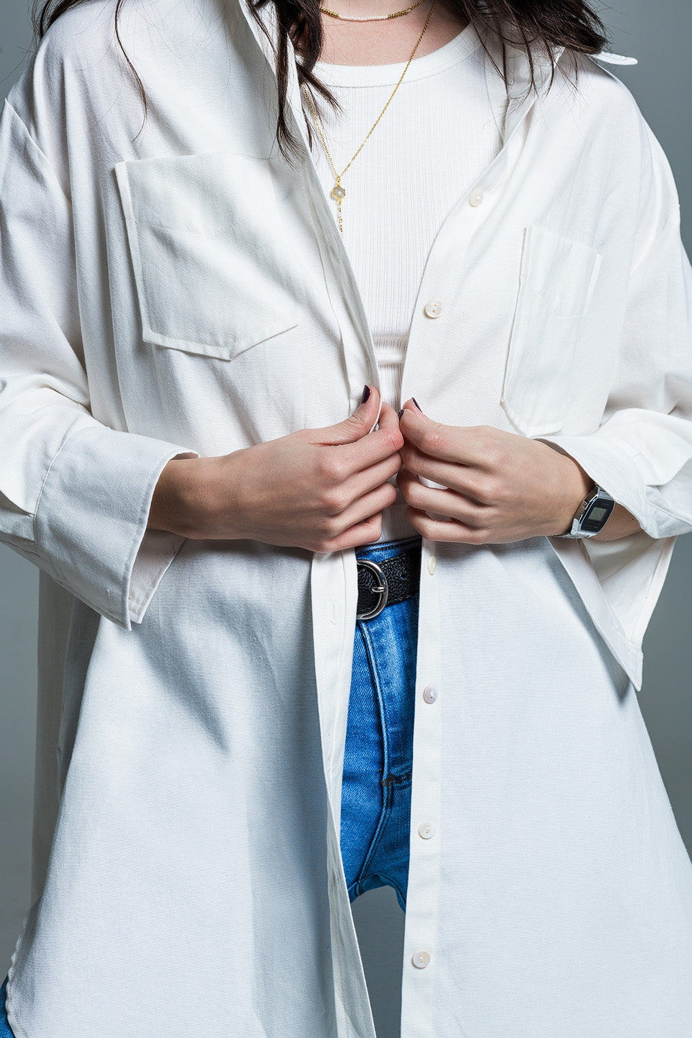 Person wearing a white lab coat layered over a white shirt and blue jeans with a neutral background. This sharp, confident lesbian outfit is a perfect example of tailored lesbian fashion and authentic lesbian style.