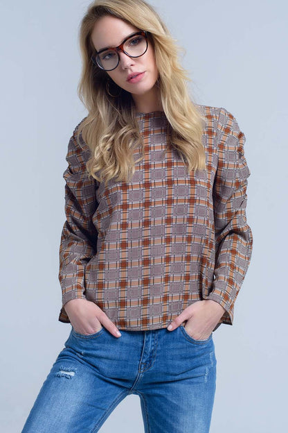 Woman wearing a classic plaid shirt and jeans against a plain background. This iconic lesbian outfit is a perfect example of casual lesbian fashion and authentic lesbian style.