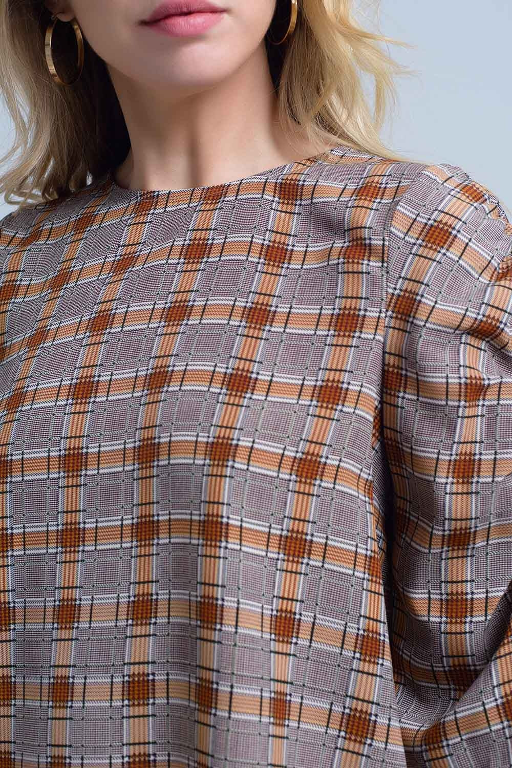Close-up of a plaid patterned fabric featuring deep brown and gray colors. This versatile material is a staple of comfortable lesbian clothing and classic lesbian style.
