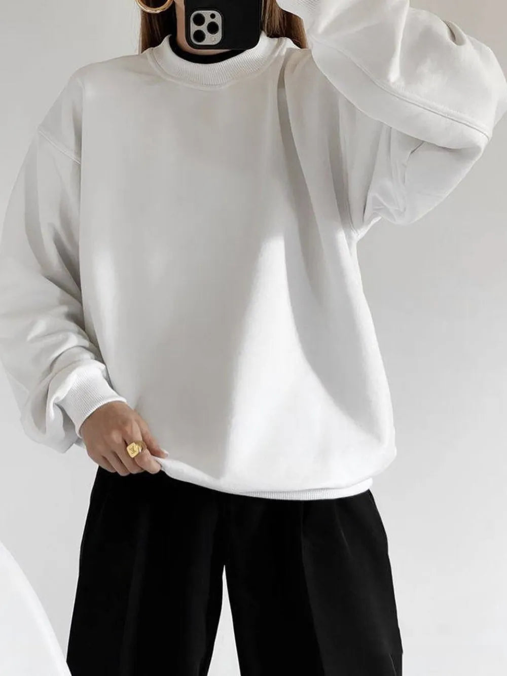 Person wearing a crisp white sweatshirt and sharp black pants against a plain background. This comfortable lesbian outfit is a perfect example of casual lesbian fashion and authentic lesbian style.