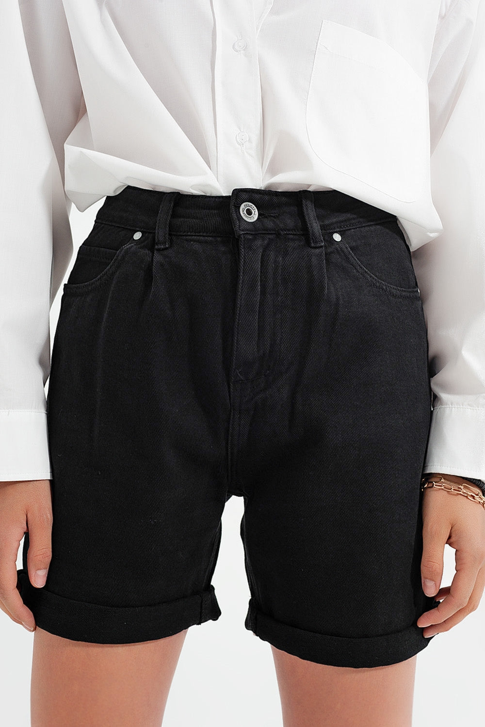 Person wearing classic black shorts and a simple white shirt against a plain background. This comfortable lesbian outfit is a perfect example of casual lesbian fashion and authentic lesbian style.