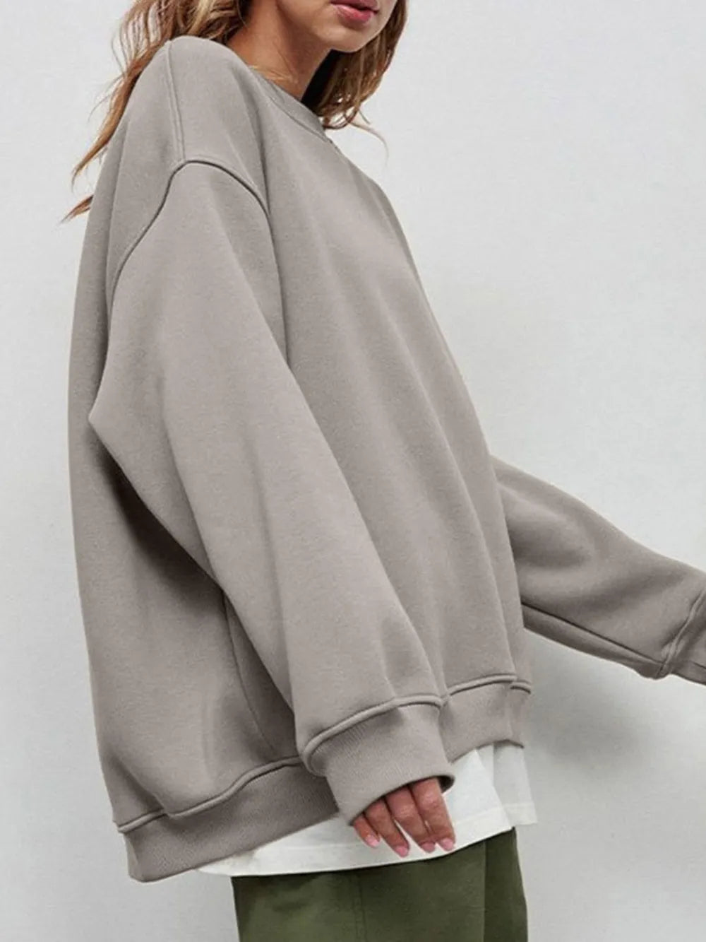 Person wearing a comfortable gray oversized sweatshirt on a plain background. This classic lesbian outfit is a perfect example of casual lesbian clothing and authentic lesbian style.