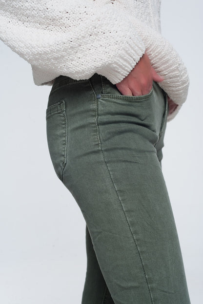 Person modeling green pants and a cozy white sweater on a plain background. This comfortable lesbian outfit is a strong example of essential lesbian clothing and confident lesbian style.