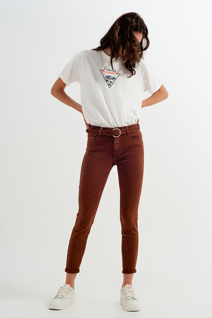 Woman wearing a white t-shirt with a graphic design and classic brown jeans on a white background. This confident lesbian outfit is a perfect example of casual lesbian fashion and authentic lesbian style.