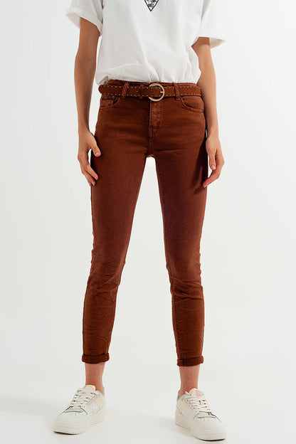Person wearing classic brown jeans and a white shirt on a white background. This clean and confident lesbian outfit is a perfect example of casual lesbian fashion and authentic lesbian style.