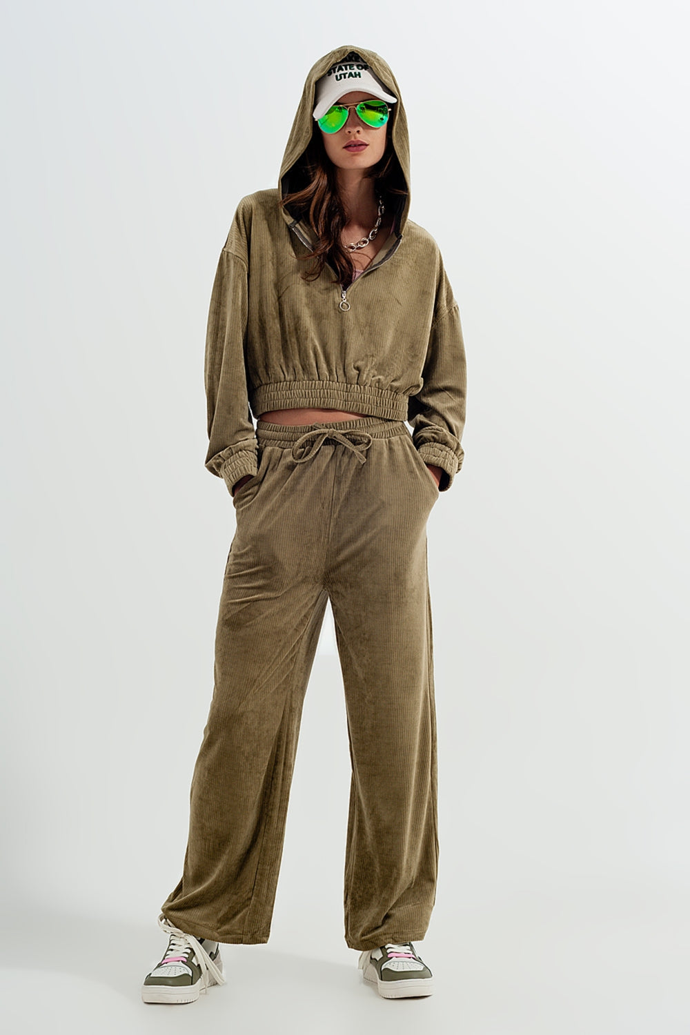 Person wearing a comfortable brown tracksuit (hoodie and sweatpants) on a white background. This relaxed lesbian outfit is a perfect example of casual lesbian clothing and authentic lesbian style.