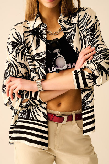 Person wearing a bold zebra print shirt layered over a black graphic t-shirt, accessorized with sunglasses, against a beige background. This confident lesbian outfit is a perfect example of statement lesbian fashion and authentic lesbian style.
